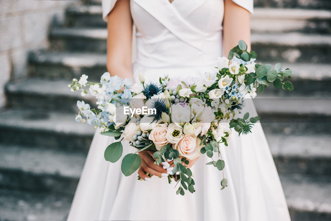 Midsection of woman holding flower bouquet