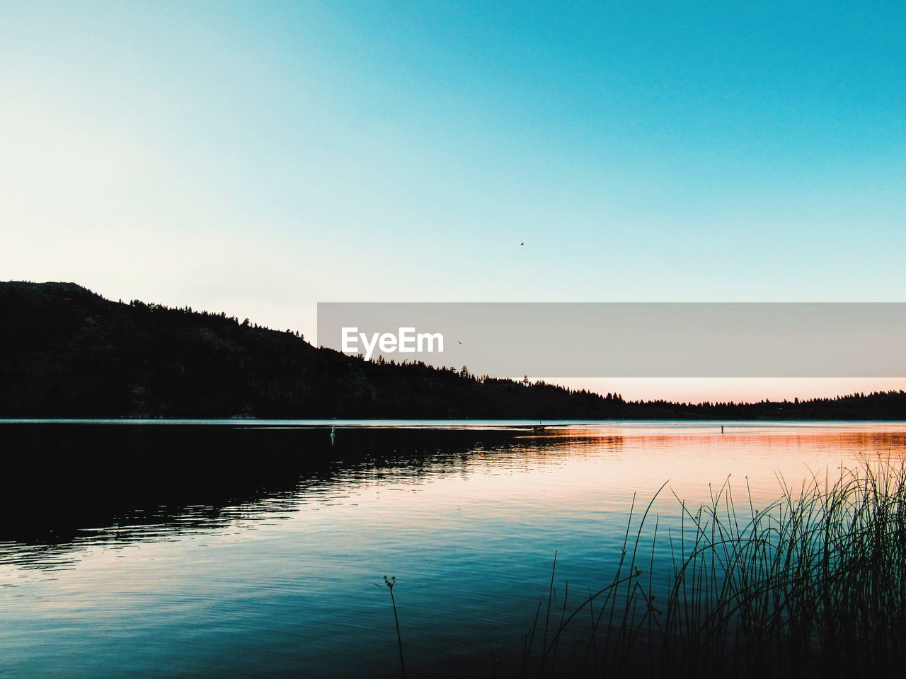 Scenic view of lake against blue sky