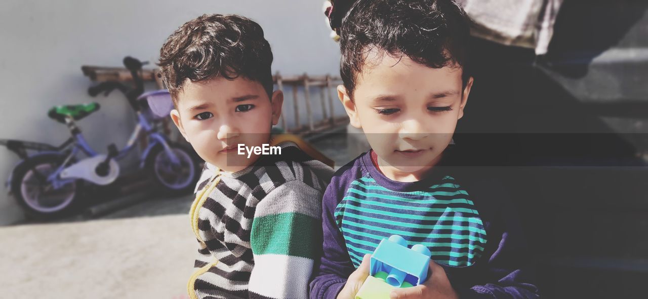 Cute kids holding toys standing outdoors