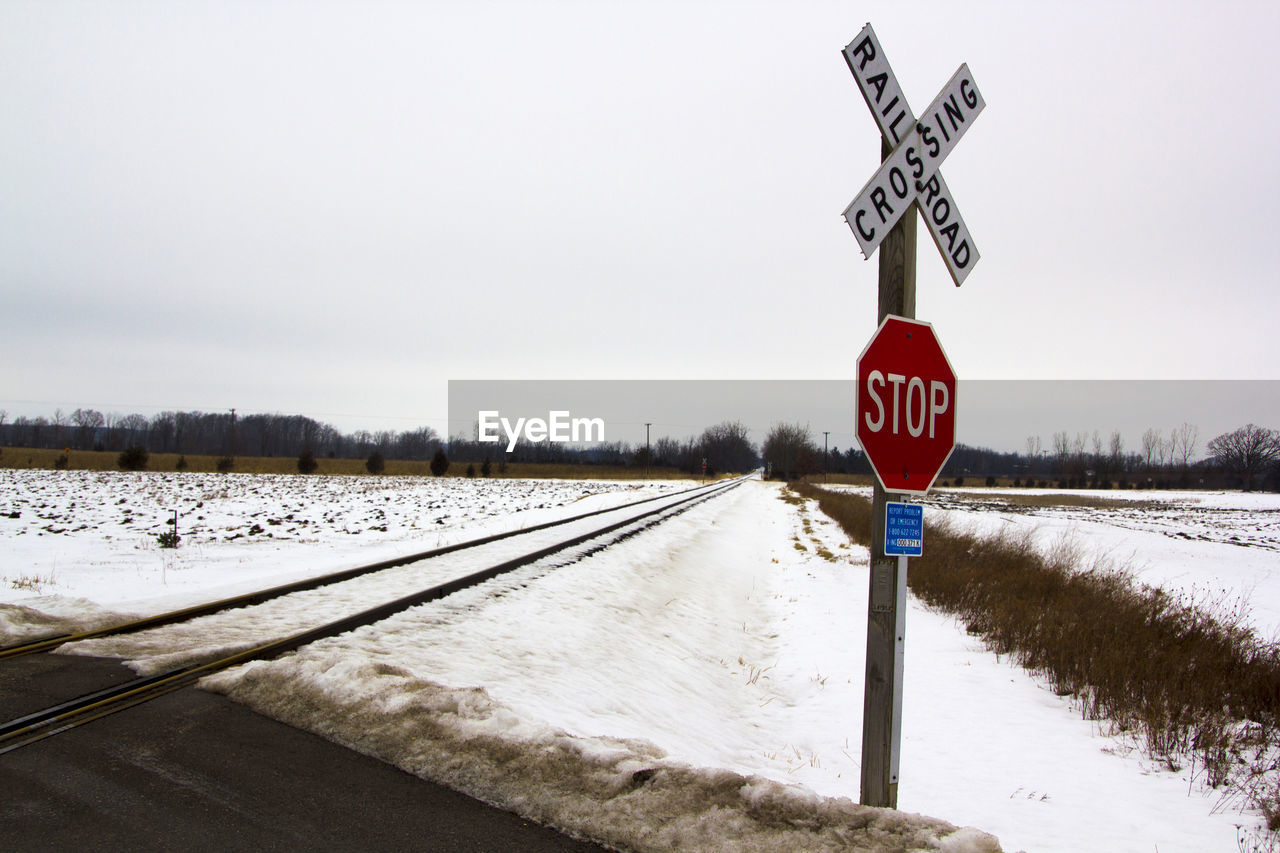 Road sign on snow against clear sky