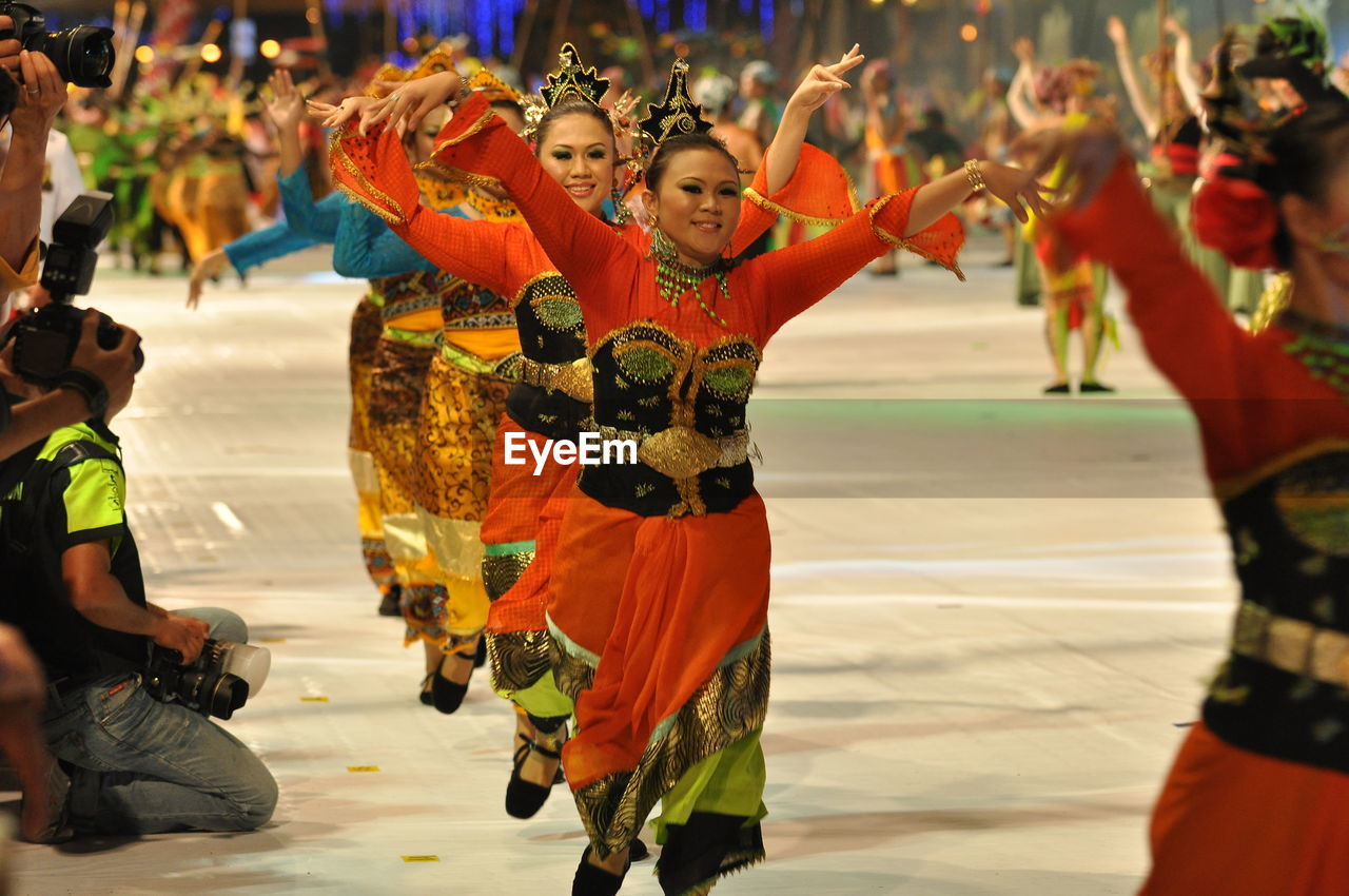 Smiling artists performing traditional dance during carnival