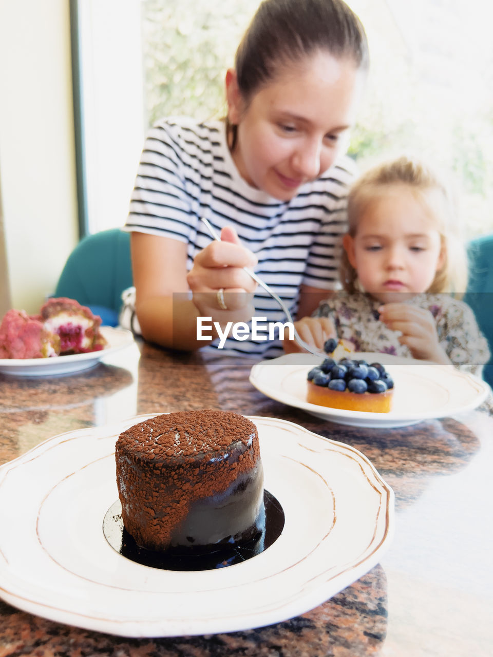 portrait of cute girl eating cookies on table