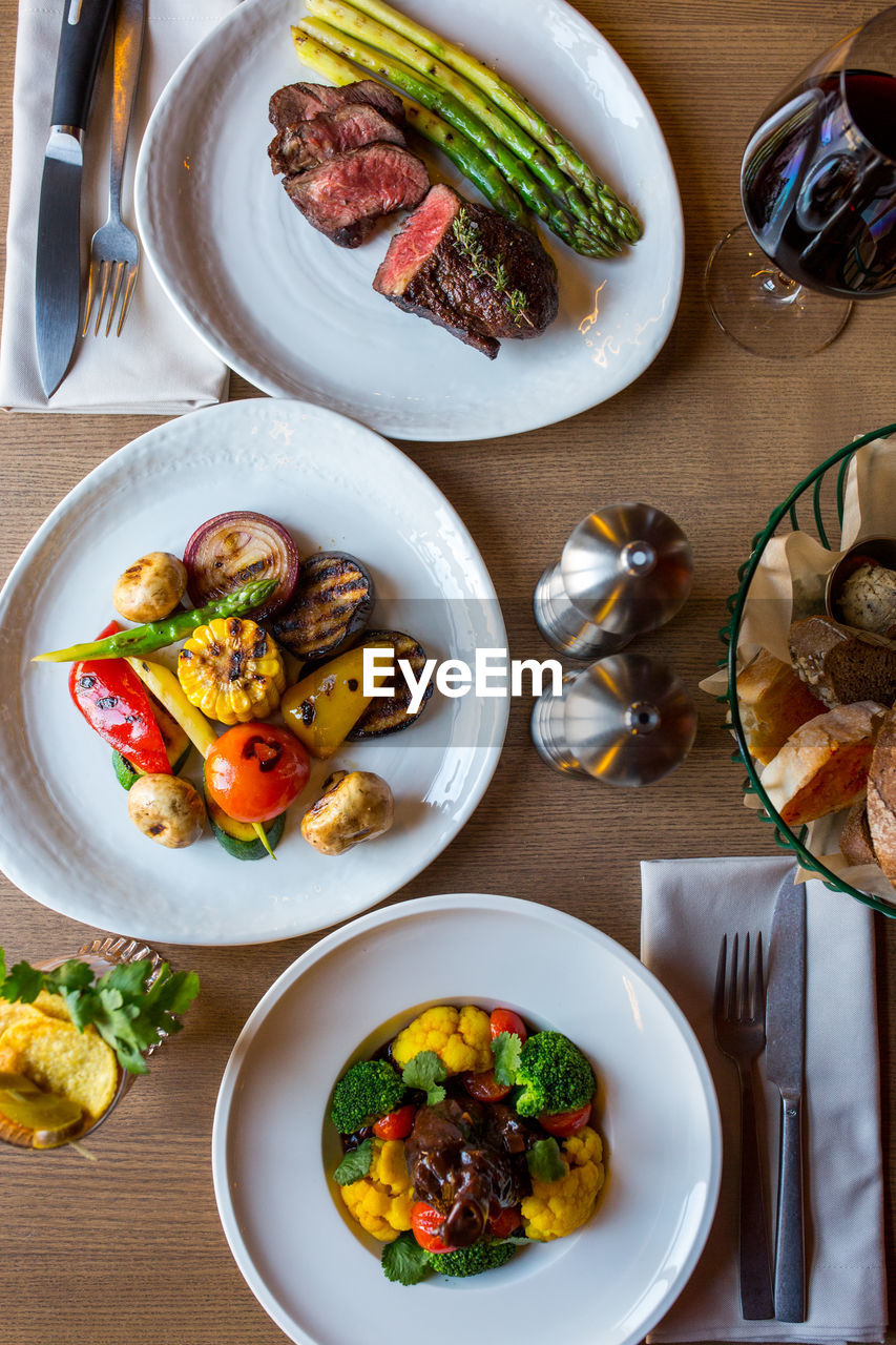 Served table with different salads and a meat dish