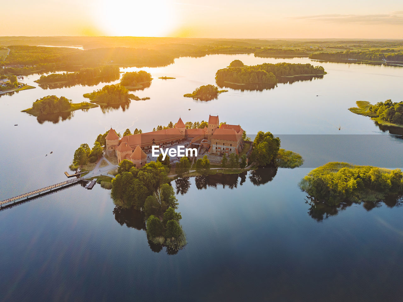 High angle view of trees by lake against sky during sunset