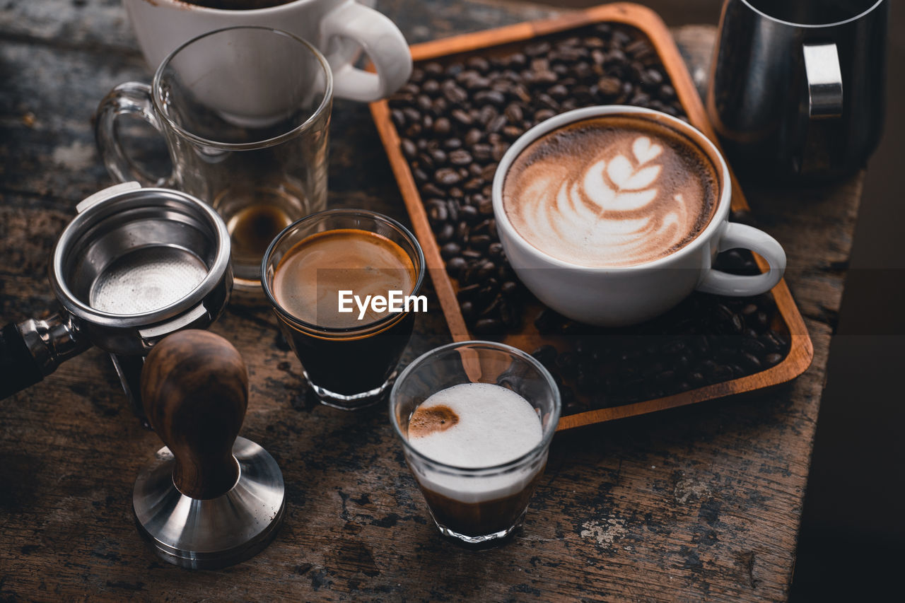 HIGH ANGLE VIEW OF COFFEE CUP ON TABLE AT CAFE