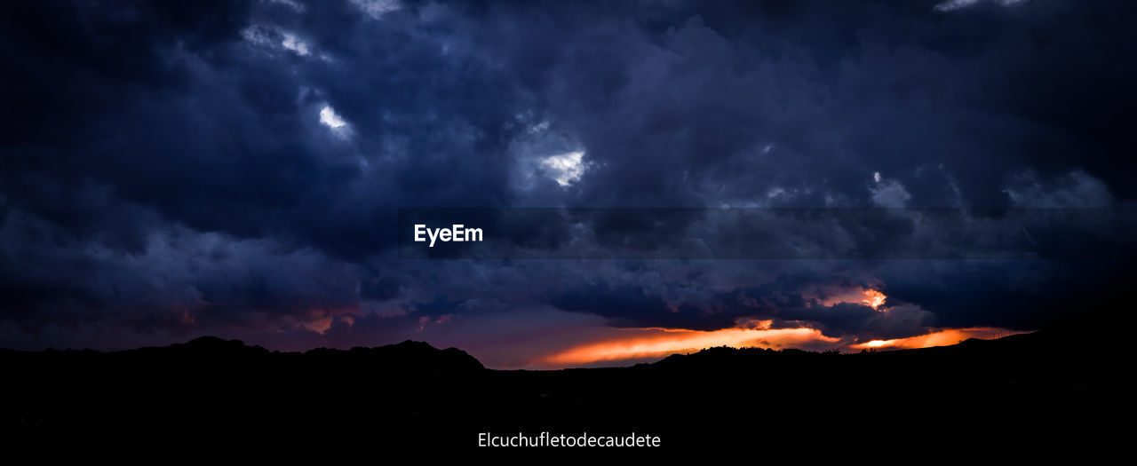 SCENIC VIEW OF SILHOUETTE MOUNTAIN AGAINST DRAMATIC SKY