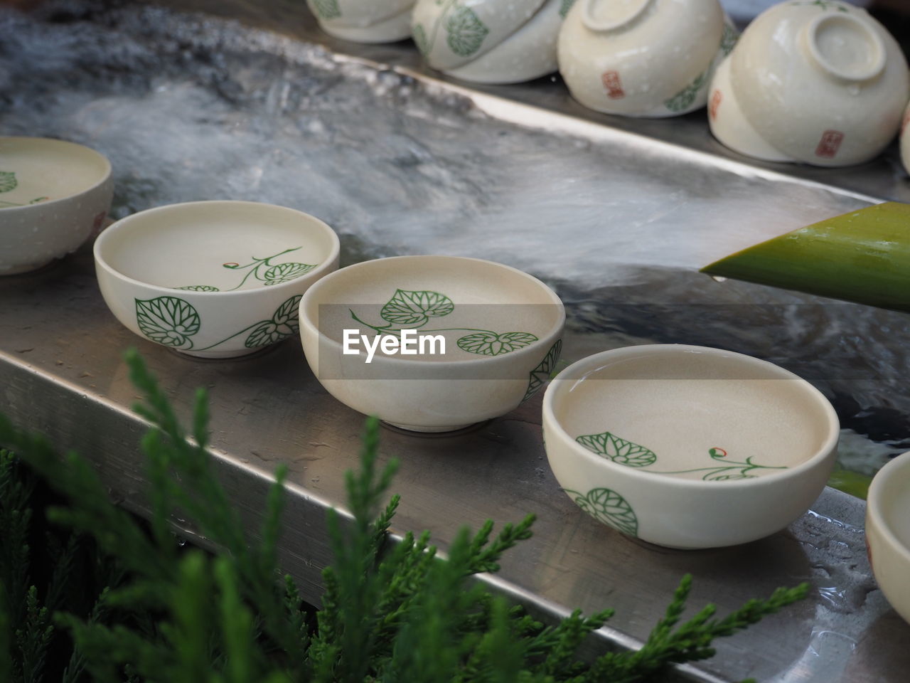 High angle view of bowl filled with water by bamboo fountain at shrine