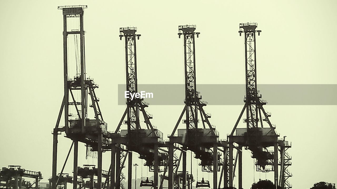 Low angle view of crane against sky