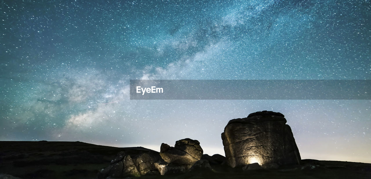 low angle view of landscape against sky at night