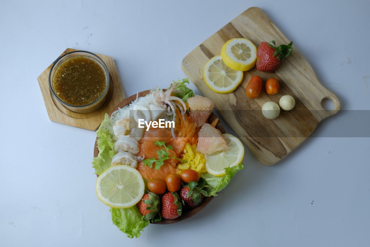 food and drink, food, healthy eating, fruit, freshness, wellbeing, vegetable, citrus fruit, lemon, dish, high angle view, indoors, no people, slice, studio shot, cuisine, meal, still life, fish, directly above, produce, tomato, table, seafood, cucumber, drink, meat, refreshment, lime