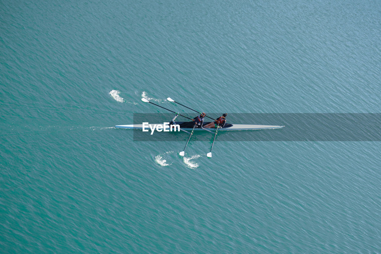 water, nautical vessel, transportation, mode of transportation, rowing, high angle view, nature, day, vehicle, wing, group of people, teamwork, waterfront, men, sports, cooperation, lake, blue, travel, outdoors, beauty in nature, aircraft, airplane, togetherness, motion, aerial view, adult, water sports, oar, copy space