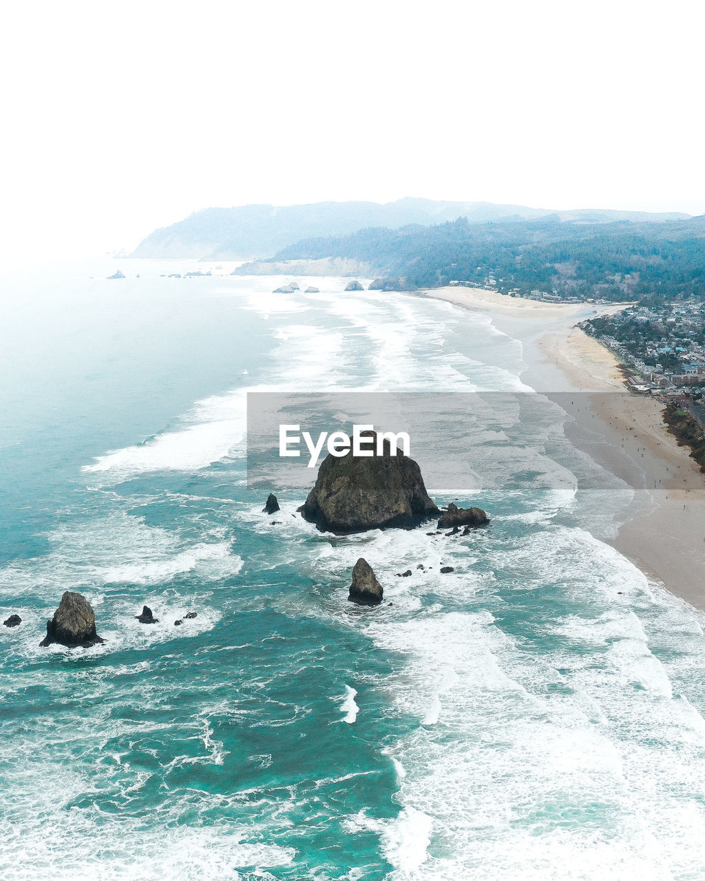 Scenic view of sea by mountains against clear sky