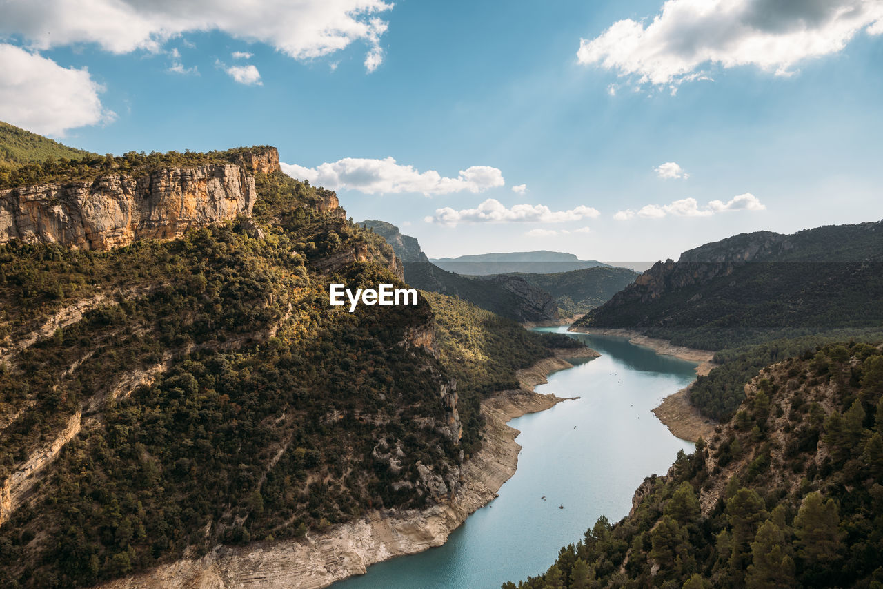 Beautiful landscape of forest and calm tranquil lake. white clouds on blue sky in aerial drone shot