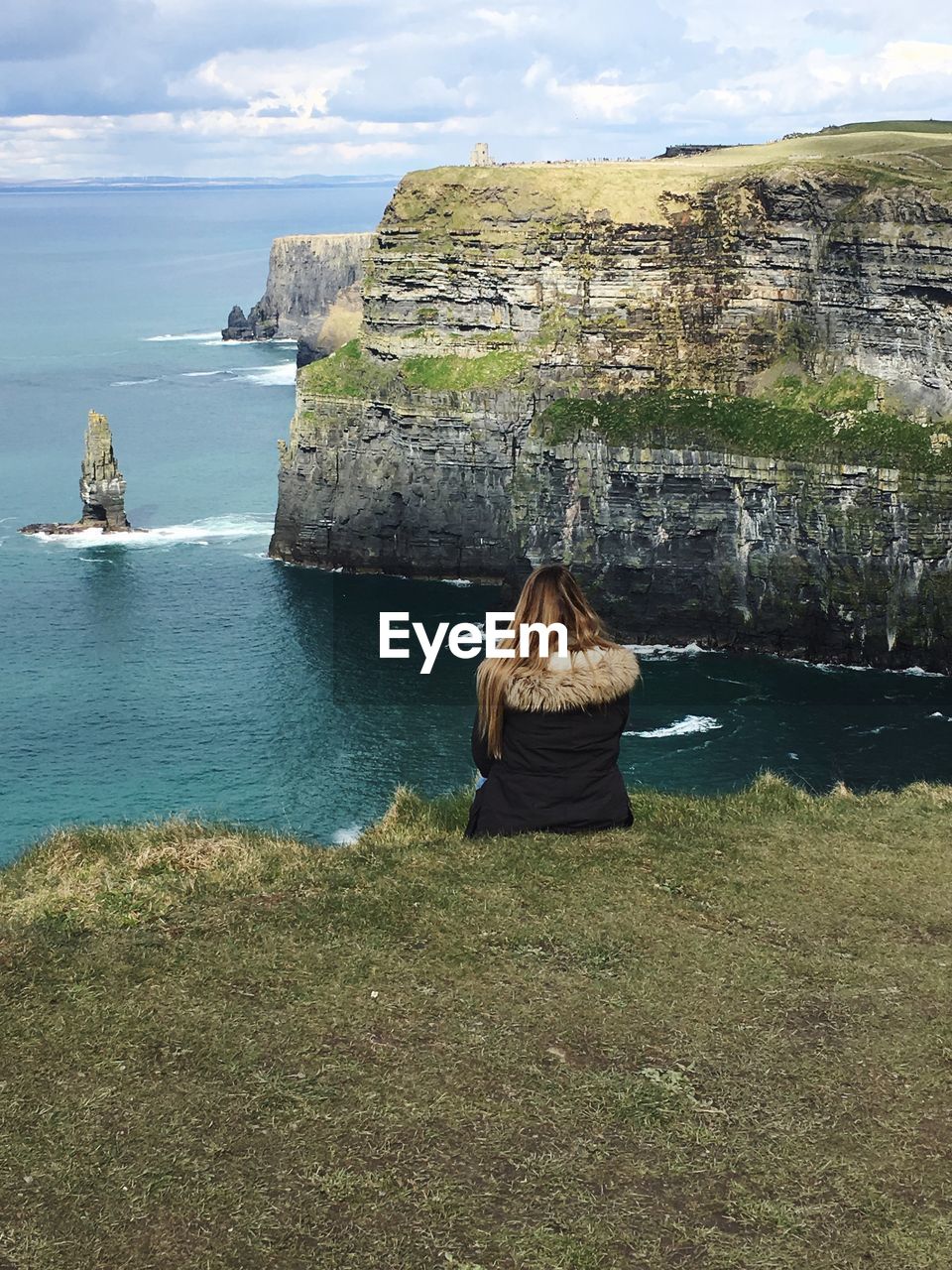 Rear view of rock formation in sea against sky