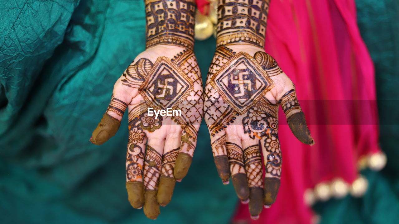 High angle view of woman showing henna tattoo during wedding ceremony