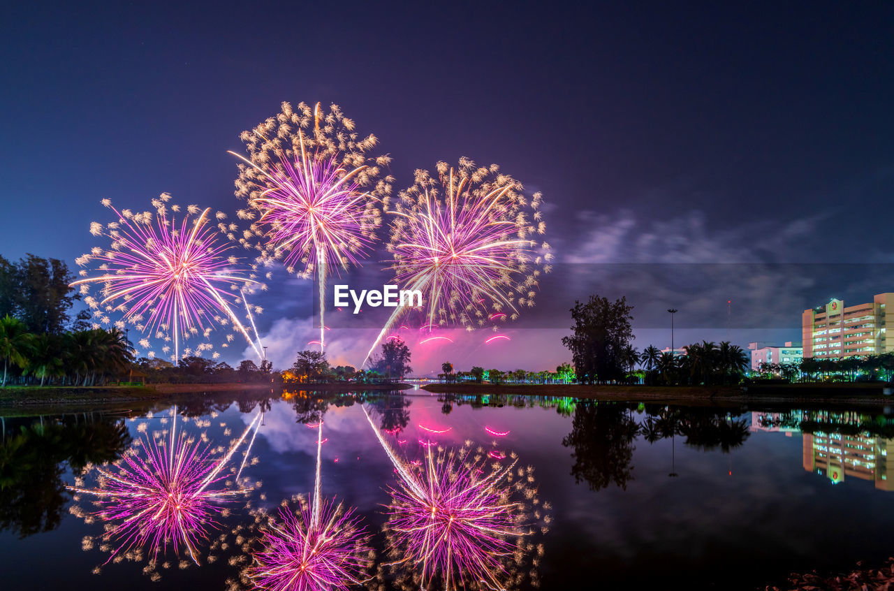 Firework display over lake at night