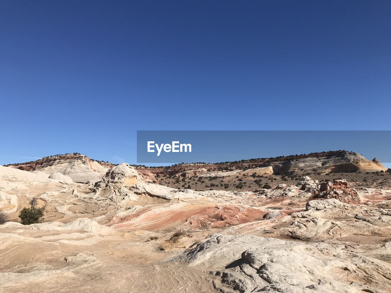 Scenic view of desert against clear blue sky