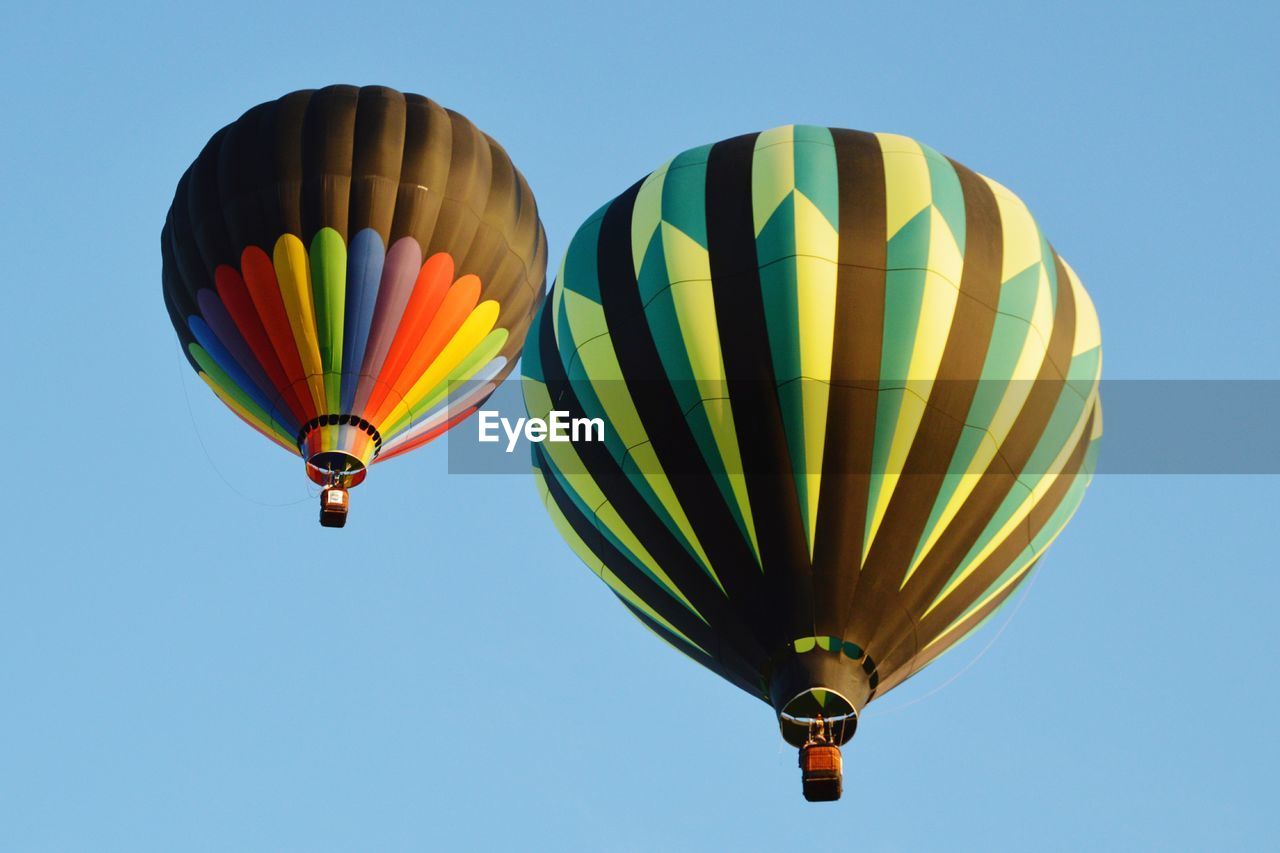 Low angle view of hot air balloons against blue sky