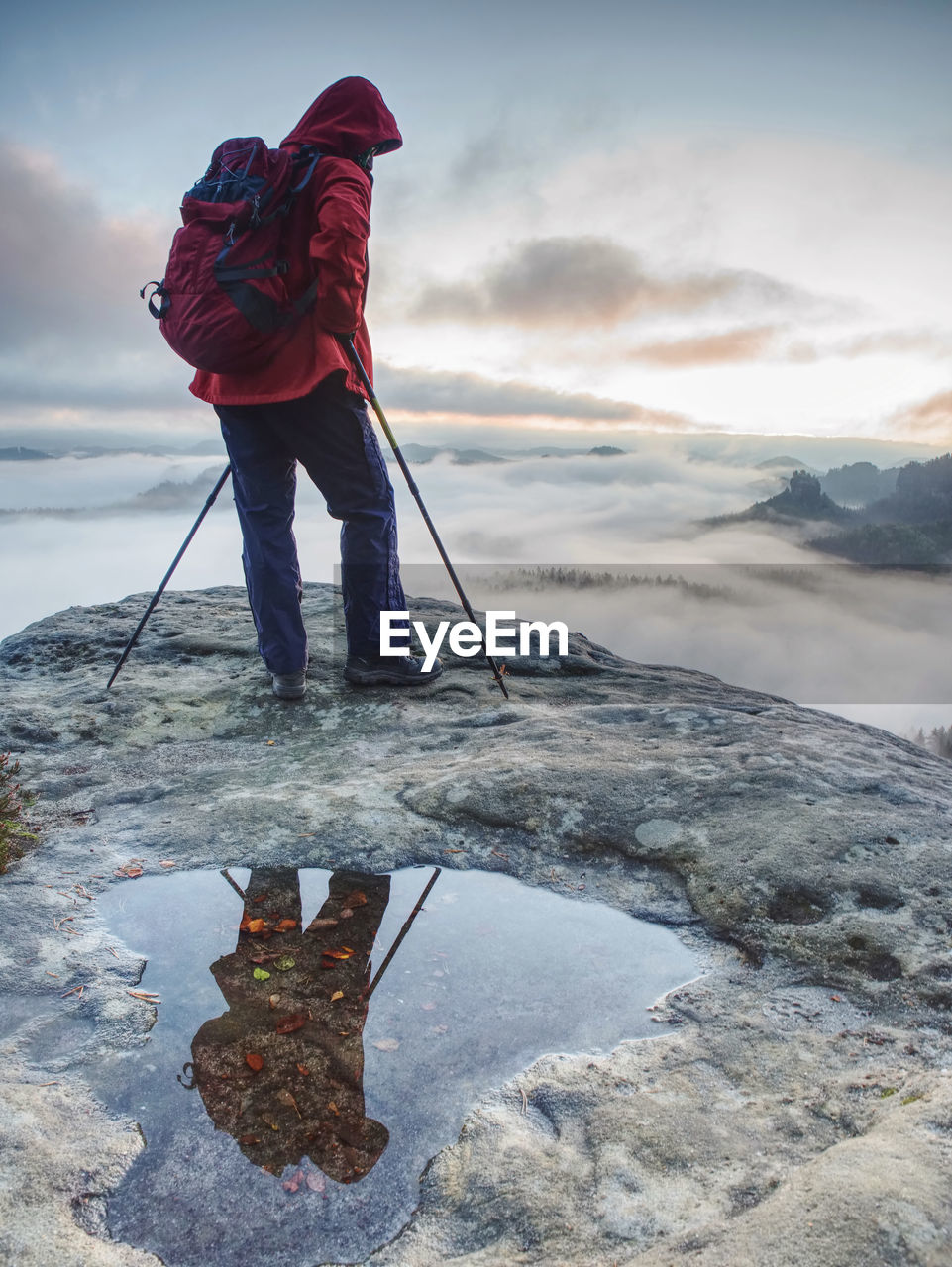 MAN STANDING ON SHORE AGAINST SKY