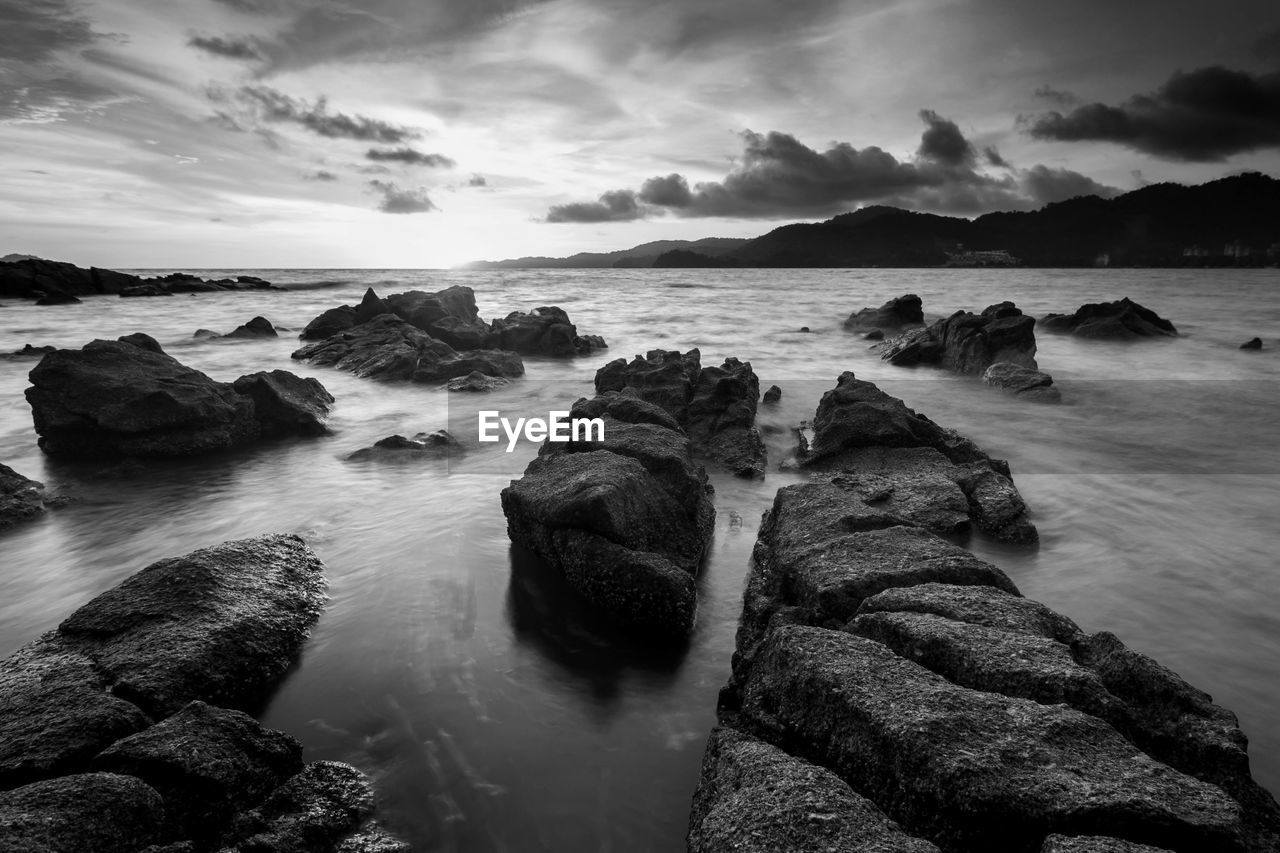 Scenic view of rocks in sea against sky