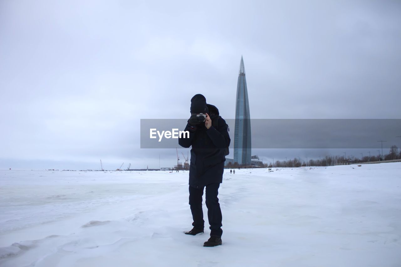 Full length of man standing on snow covered land