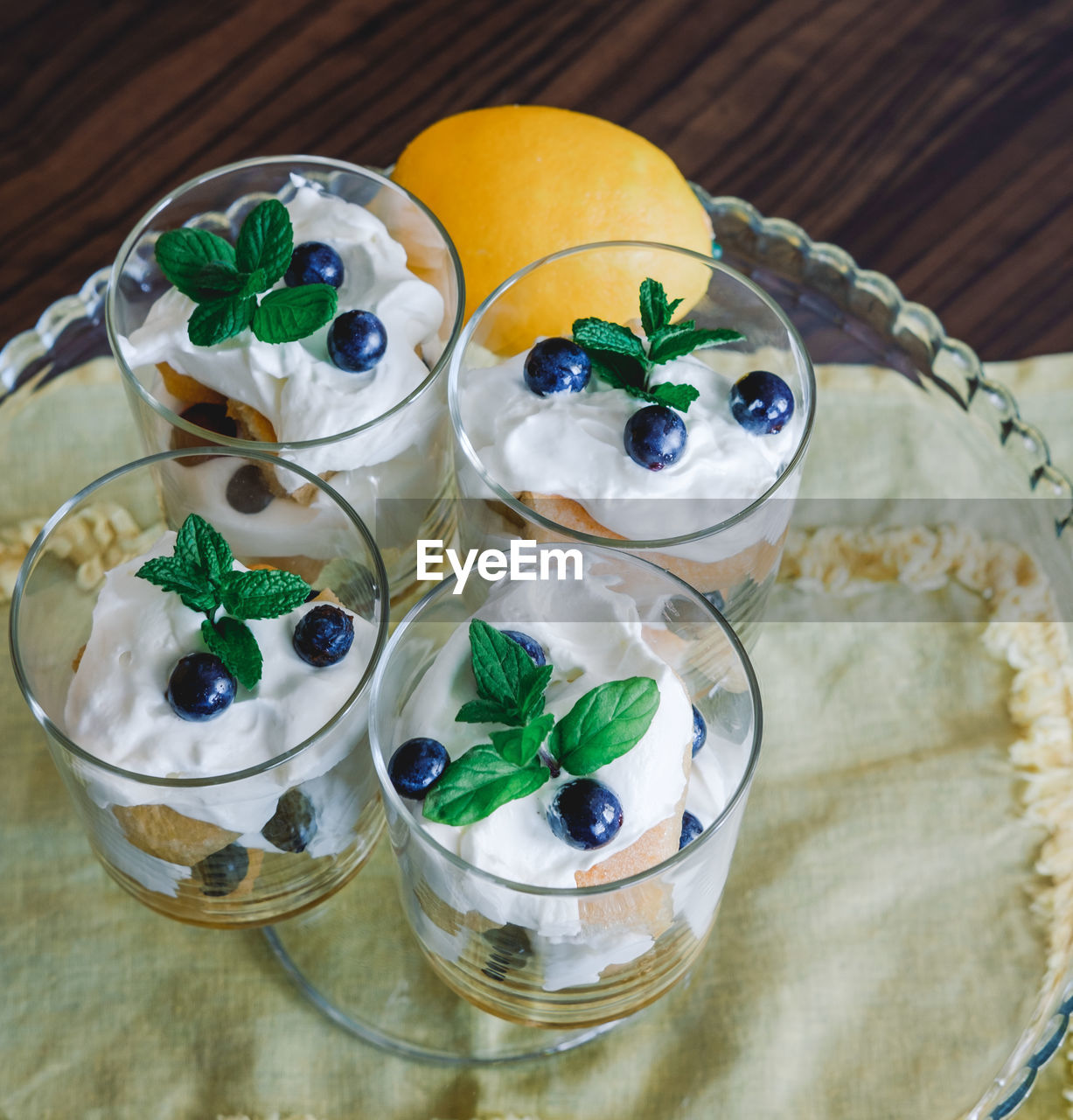 Homemade tiramisu with lemons served on table. top view of delicious dessert in glass cups.