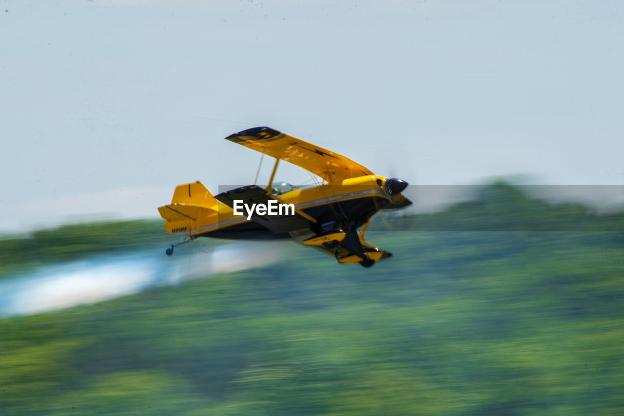 AIRPLANE FLYING OVER YELLOW WATER