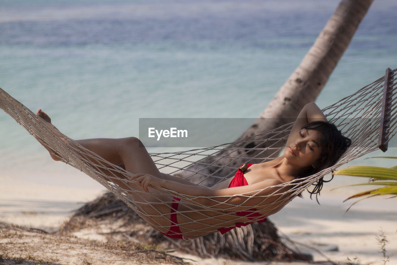 Low angle view of woman sitting on beach