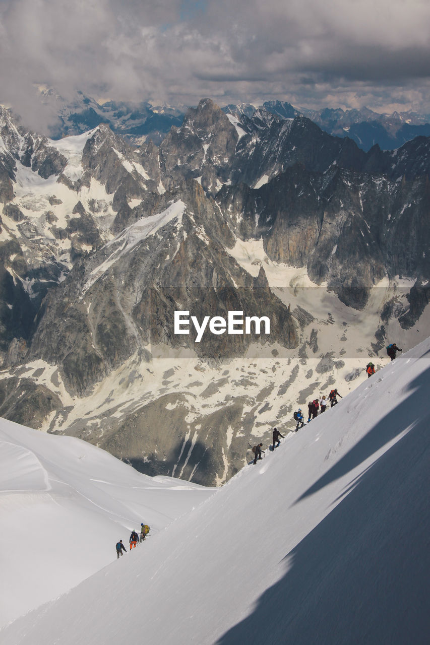 High angle view of people climbing snowcapped mountain