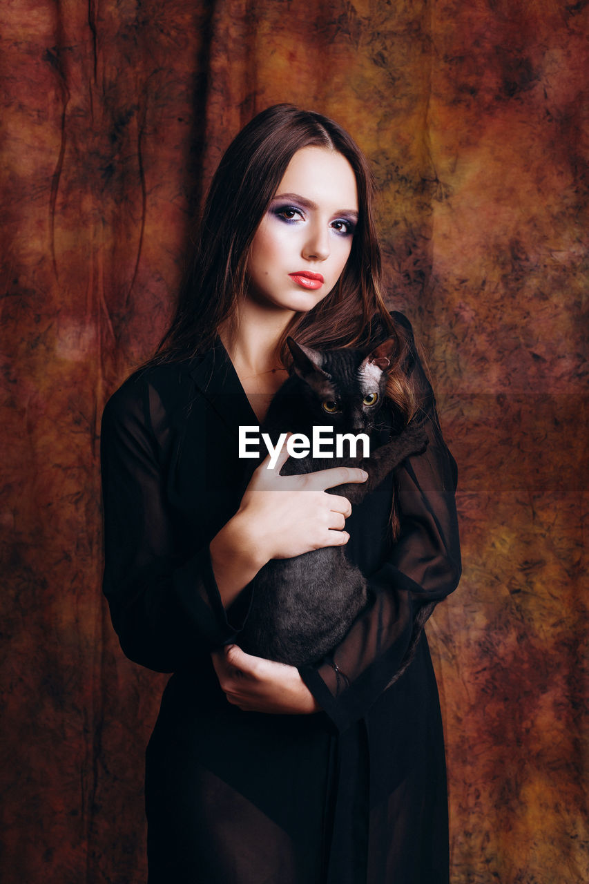 Portrait of teenage girl holding cat