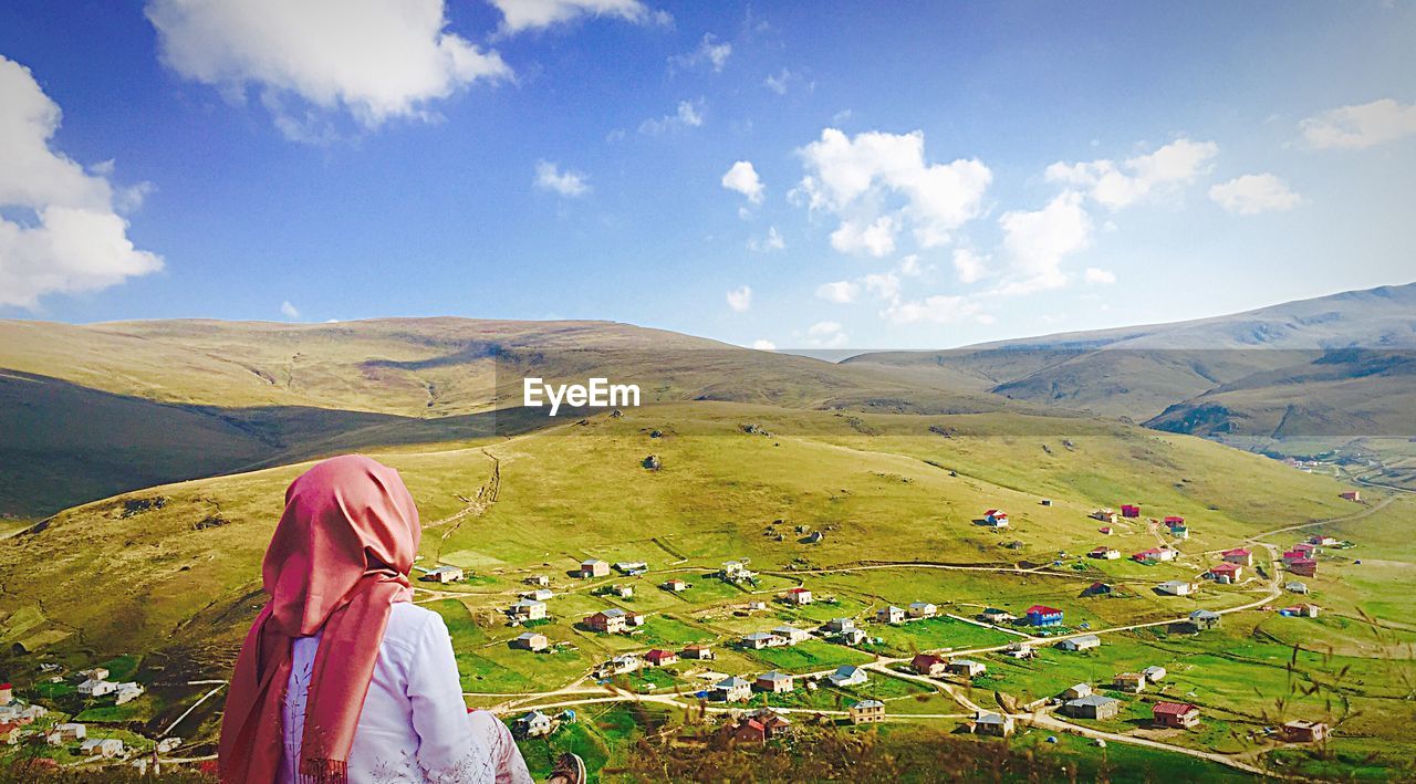 Rear view of woman on landscape against sky