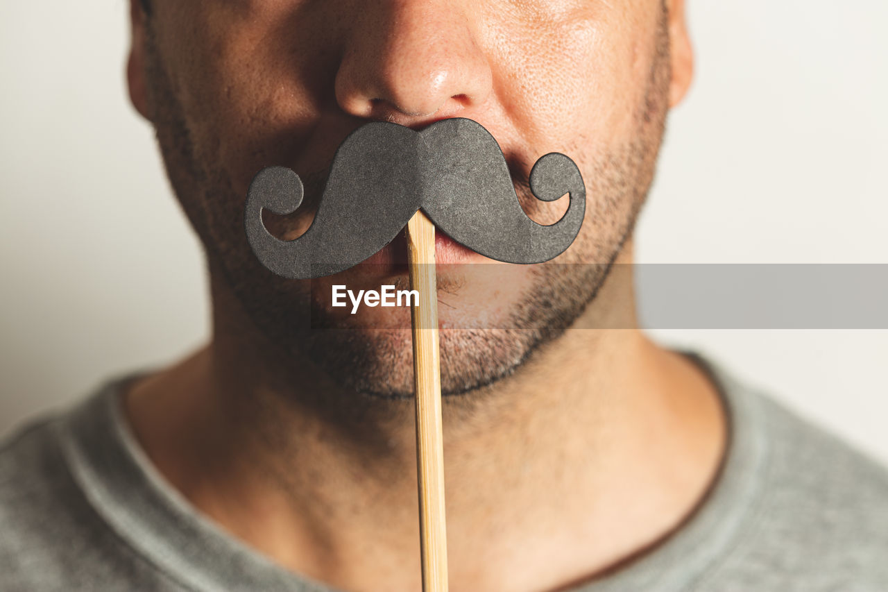 Close up of a man wearing a prop black mustache