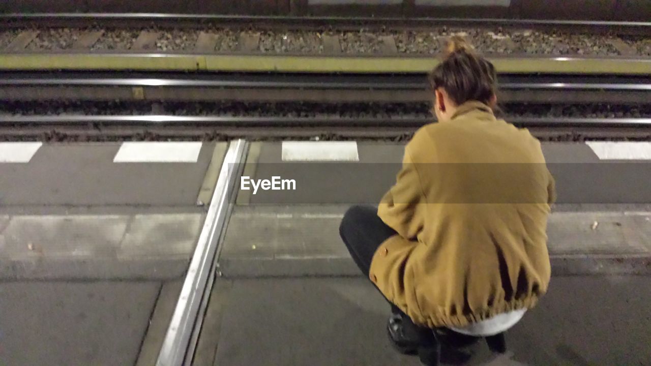 Young woman crouching on platform