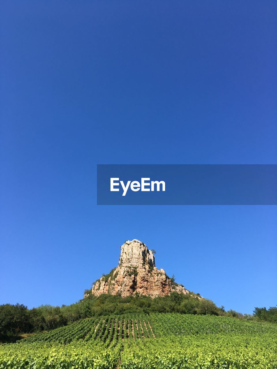 Scenic view of land against clear blue sky ... roche de solutré