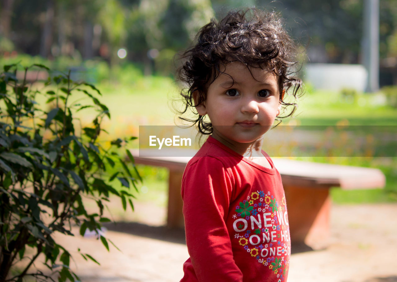 BOY WITH BABY GIRL IN BACKGROUND