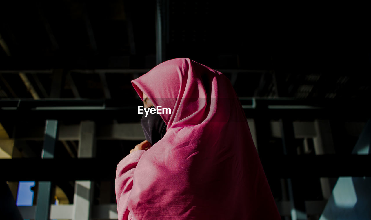 Low angle view of woman wearing hijab praying at home