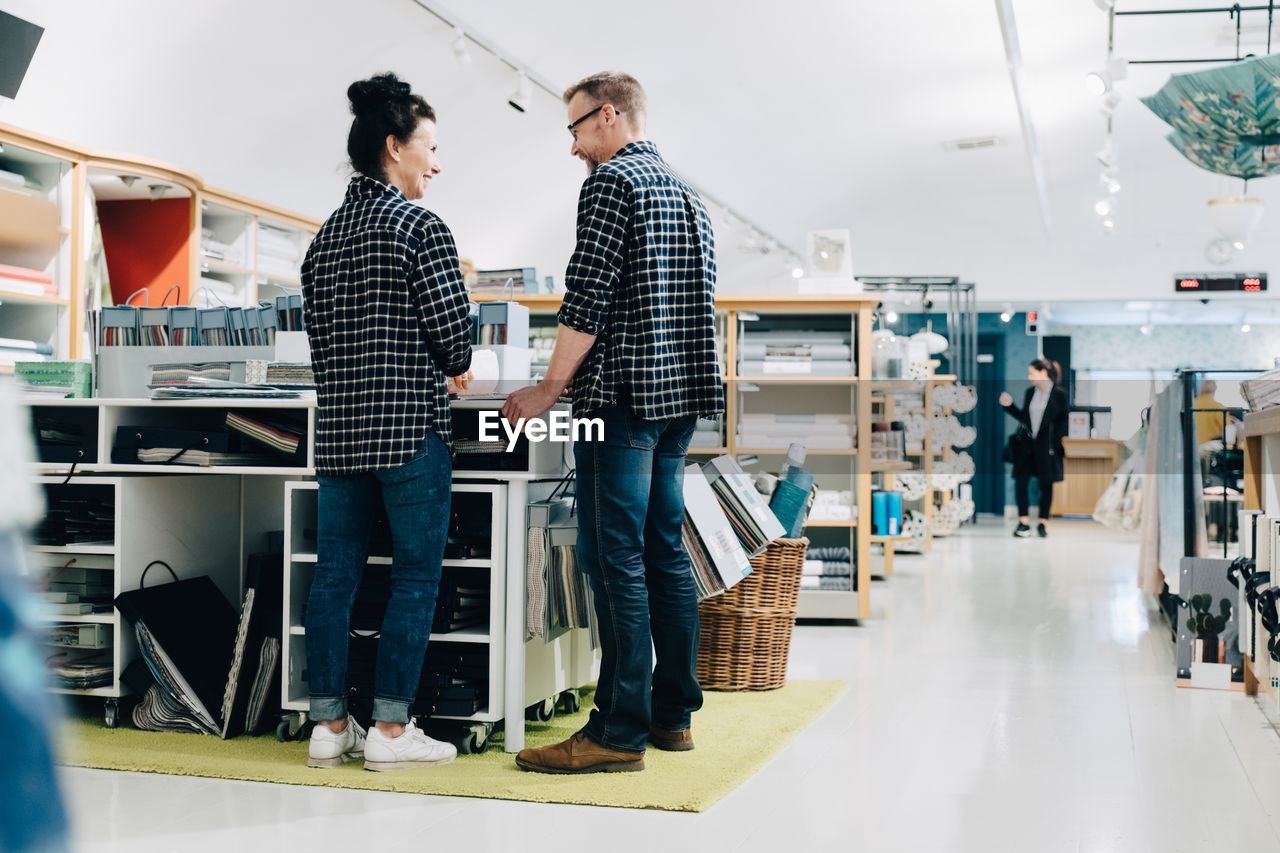 Full length of smiling coworkers working in store