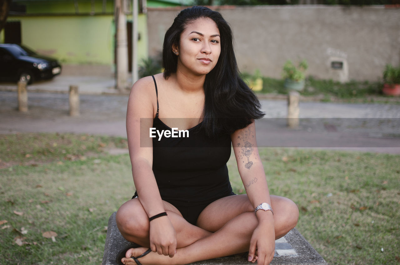 Portrait of young woman sitting outdoors