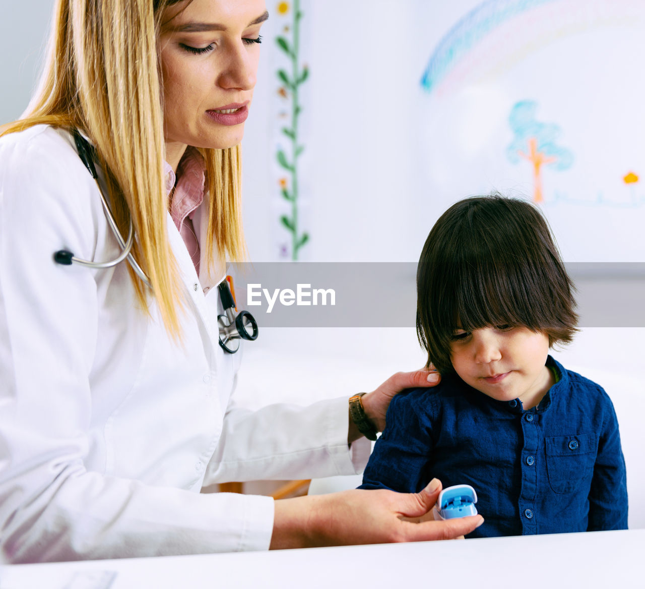 Female doctor examining boy in hospital