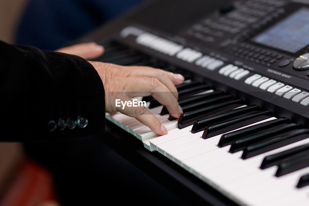 Cropped hands of person playing piano