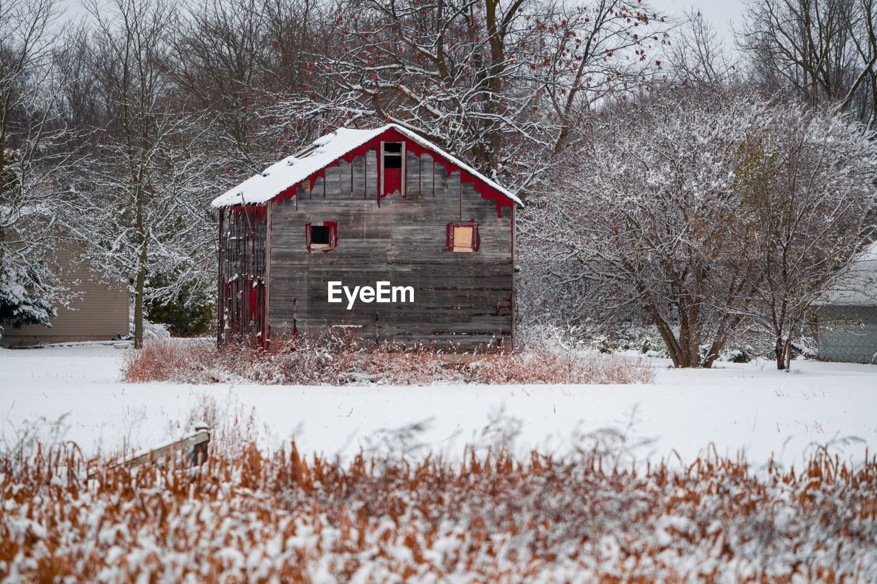 Old barn or house on snow covered field