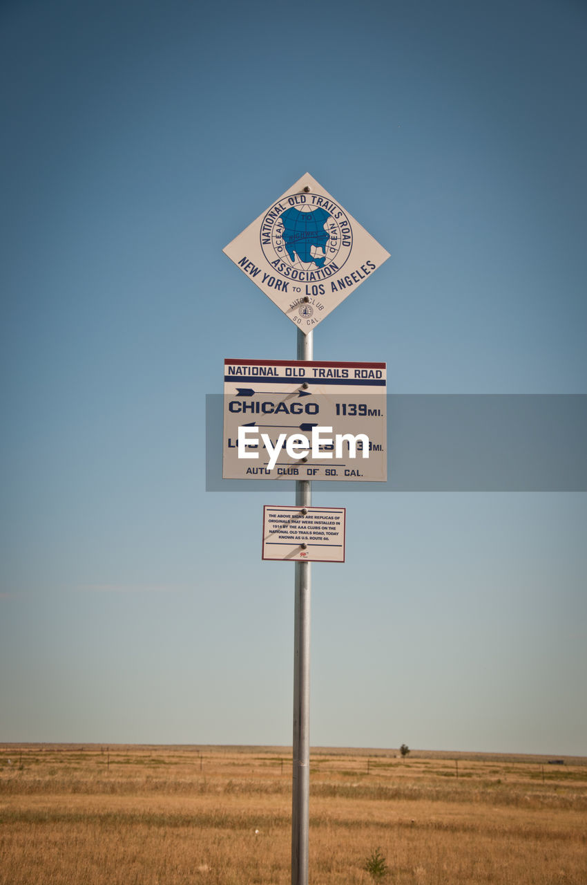 Information sign on field against clear sky