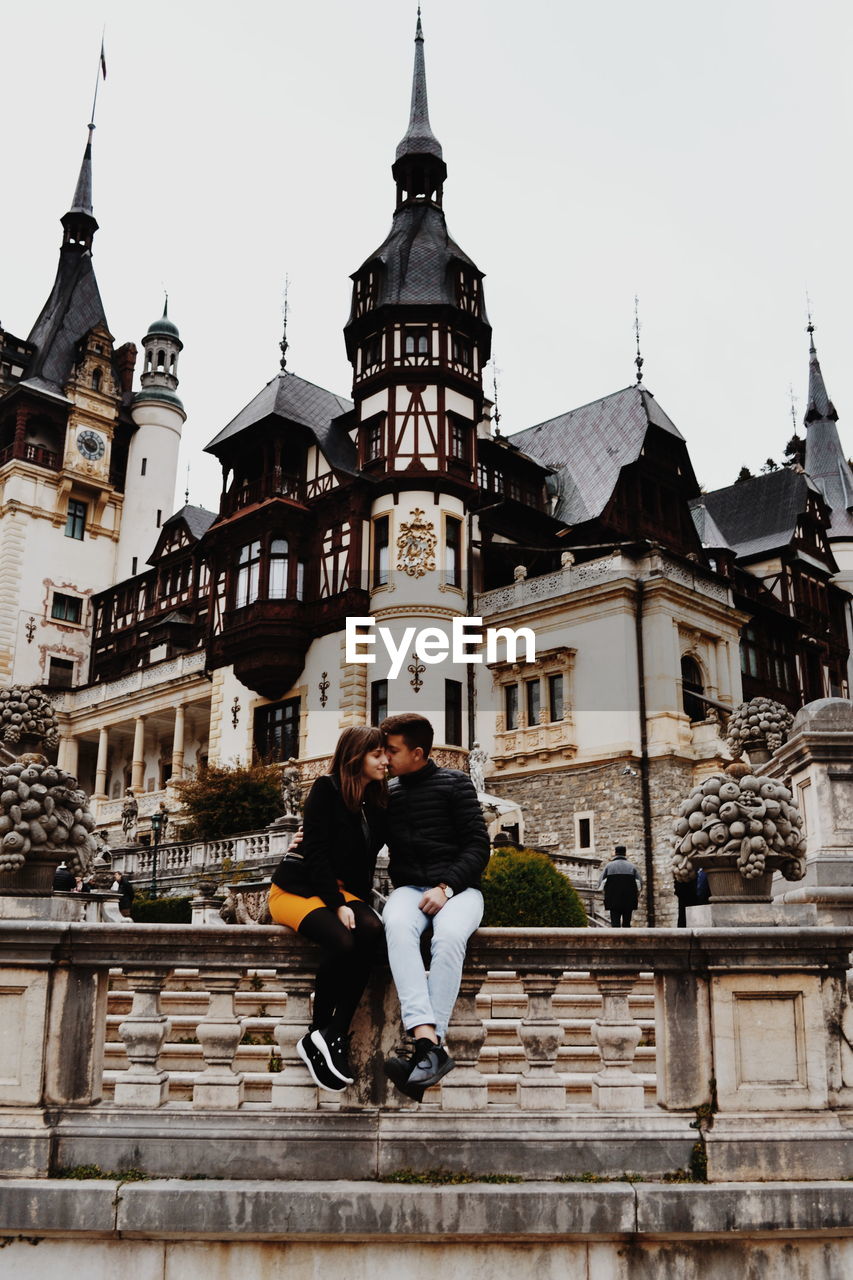 Couple doing romance while sitting against church