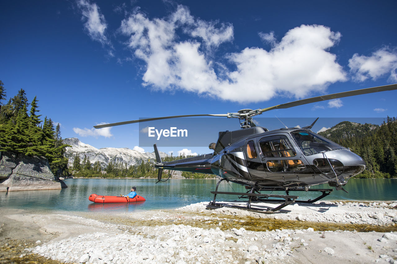 Helicopter pilot floats on lake under the tail of his helicopter