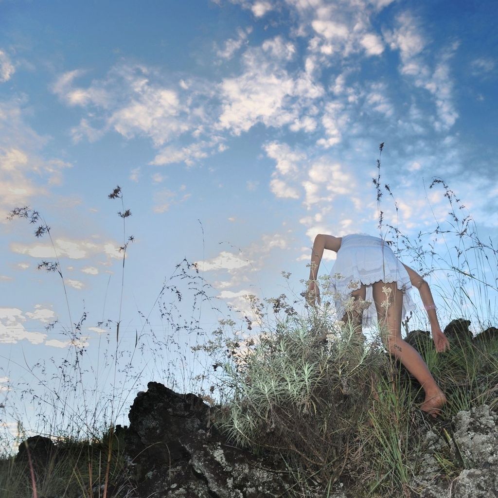 Low angle view of young woman walking on field