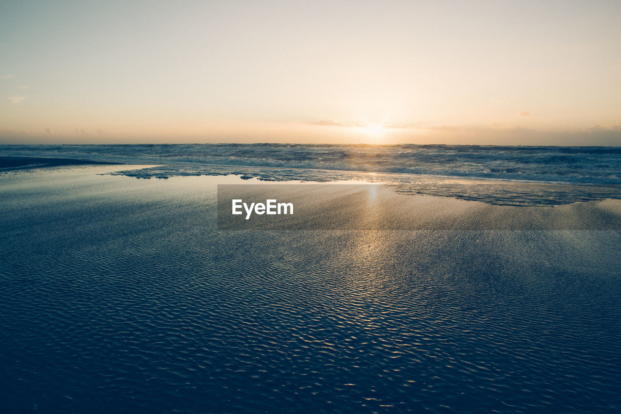 Scenic view of sea against clear sky during sunset