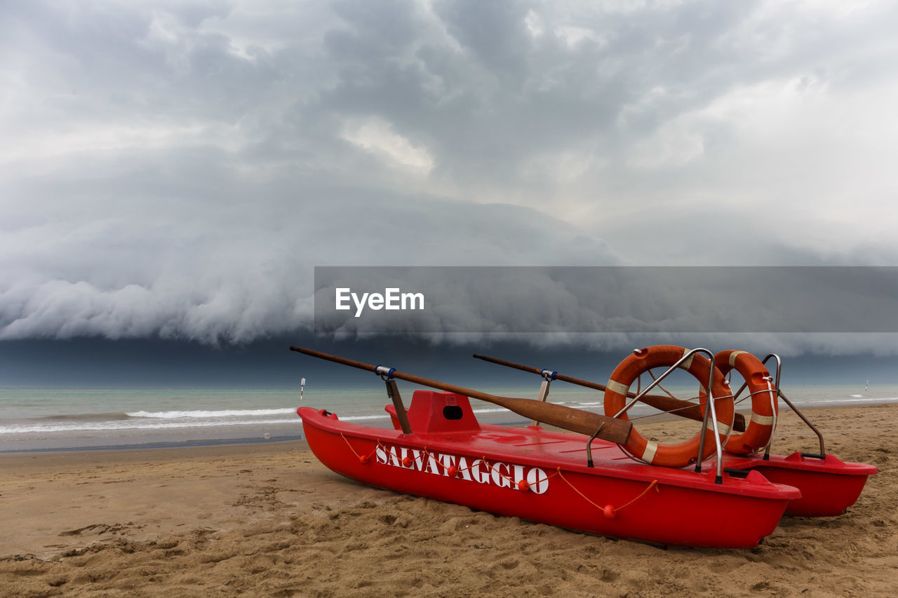 Boats moored on beach against sky