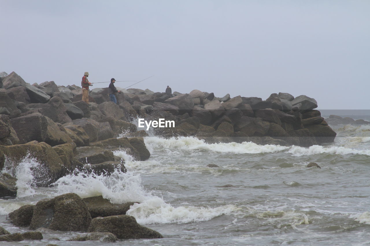 ROCK FORMATIONS ON SEA AGAINST SKY