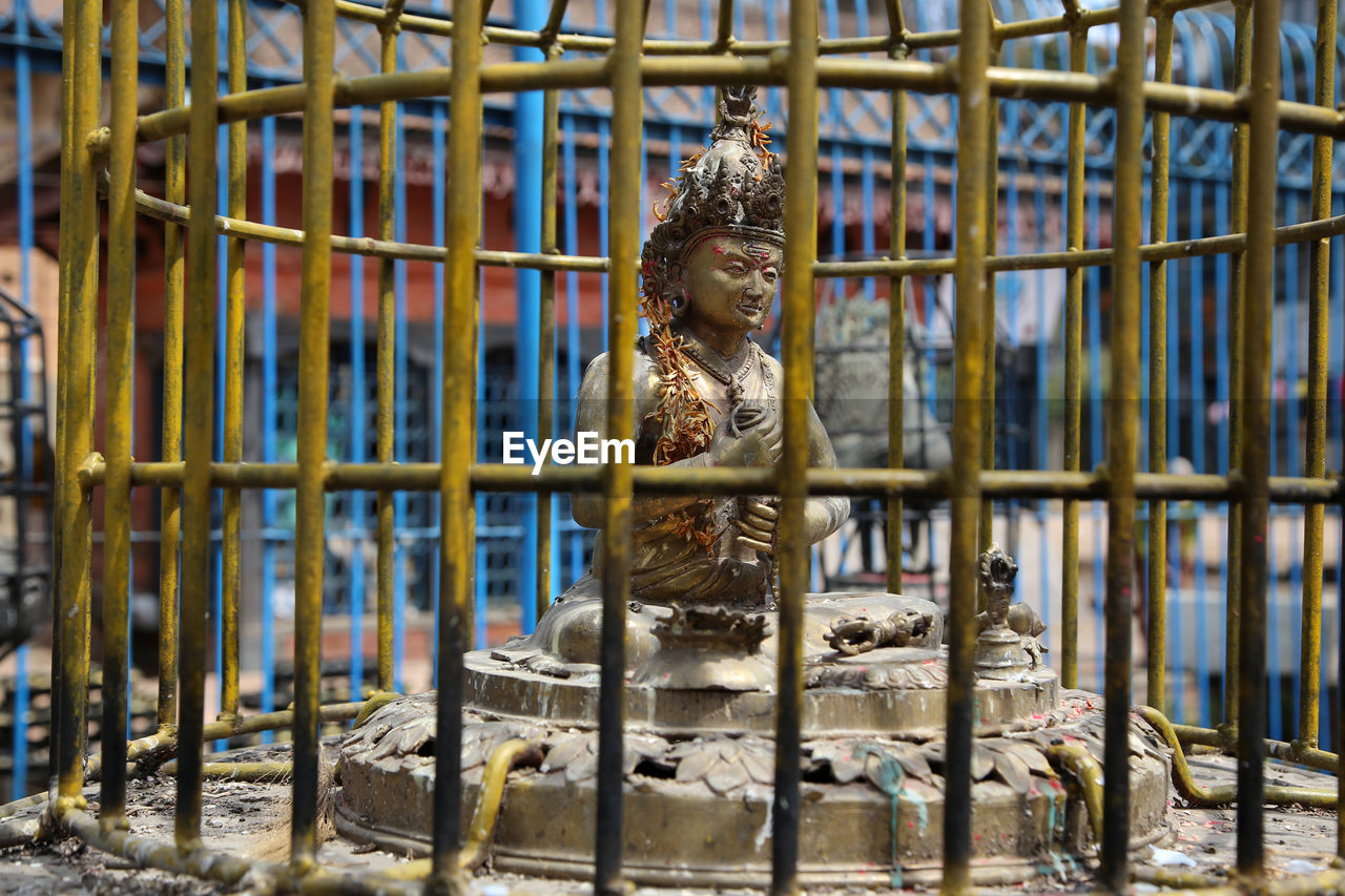 Statue in cage at buddhist temple