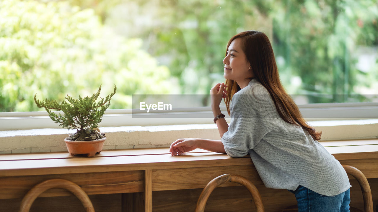 portrait of young woman sitting on chair at park